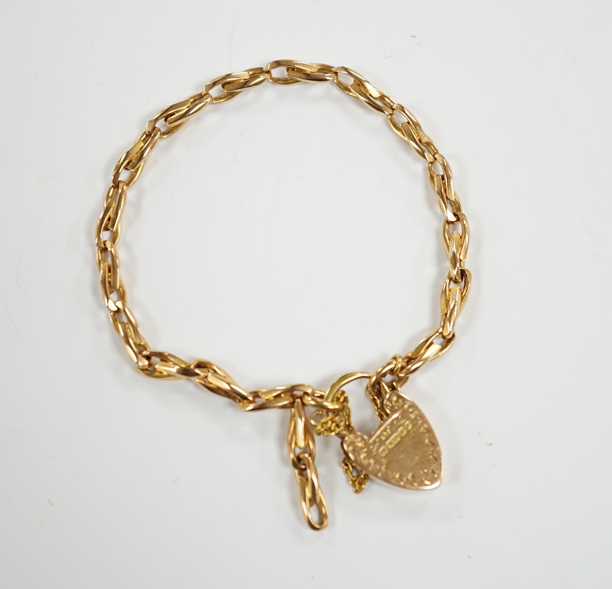An Edwardian 15ct gold oval link bracelet with heart shape padlock clasp, 18cm, 24.6 grams.